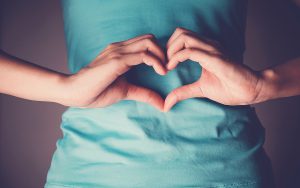 Cómo prevenir el cáncer de colon - Manos formando corazón sobre el vientre